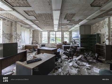 Abandoned office furniture left behind in an abandoned insane asylum stock photo - OFFSET