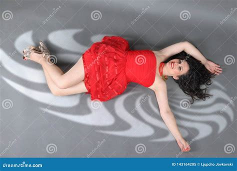 Attractive, Gorgeous and Pretty Girl Lying on the Floor on Red Dress in the Studio Poses Stock ...