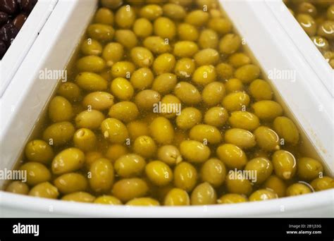 Green olives in brine in supermarket Stock Photo - Alamy