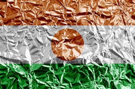 Niger Flag Depicted in Paint Colors on Shiny Crumpled Aluminium Foil Closeup. Textured Banner on ...