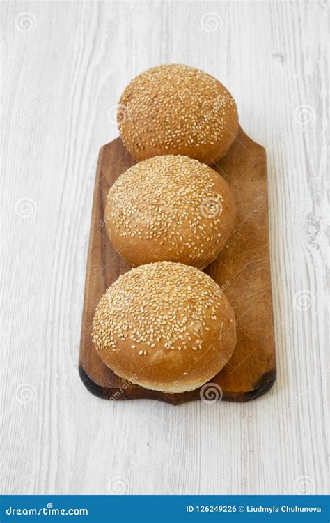 Fresh Burger Buns with Sesame Seedson Wooden Board Over White Wooden ...