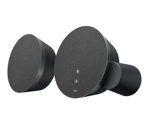 two black speakers sitting next to each other on top of a gray surface with white dots