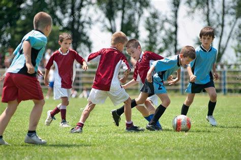 Kids playing football Stock Photo by ©fotokostic 20997099