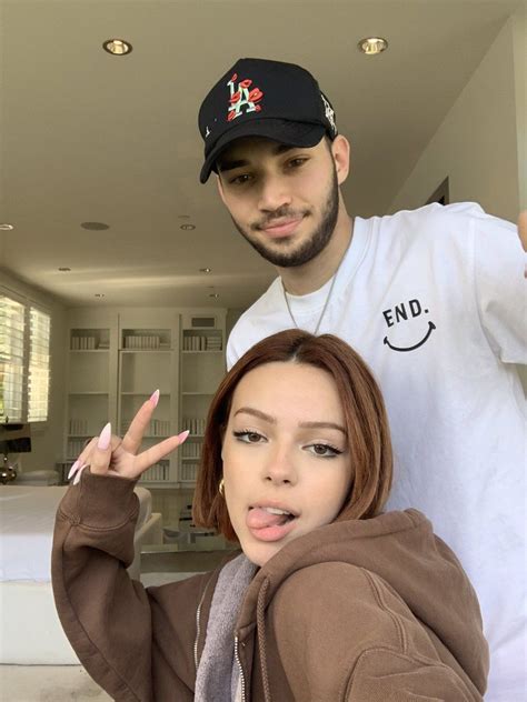 a man and woman posing for a photo in front of a bed