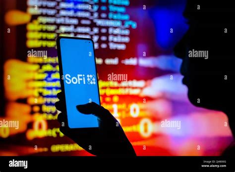 In this photo illustration, a woman holds a smartphone with the SoFi Technologies logo displayed ...