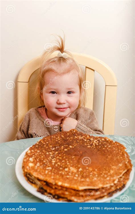 Beautiful Little Girl Sits at a Table with Large Round Pancakes. Carnival Festival Stock Photo ...