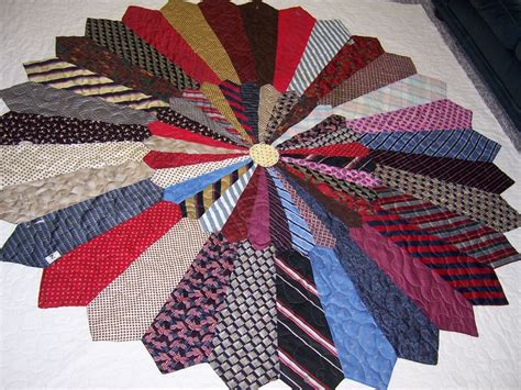 a large group of ties laid out on top of a quilted bed coverlet