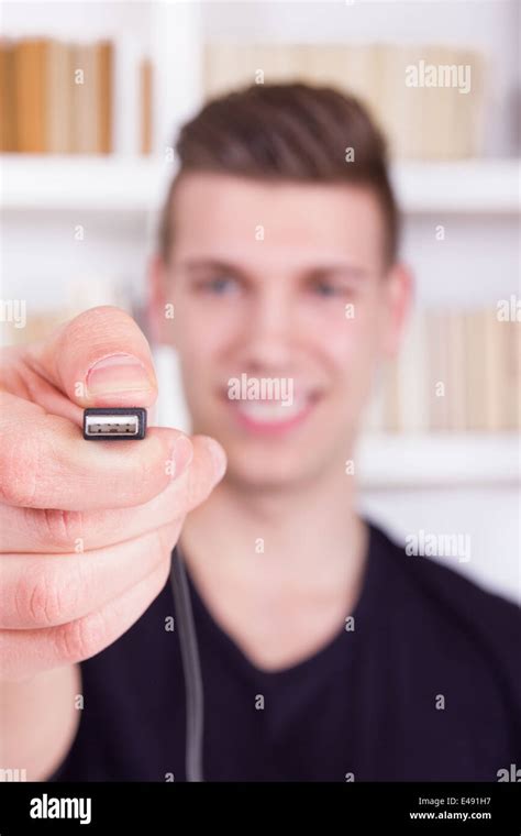 smiling man holding and showing black USB cable, usb port connector ...
