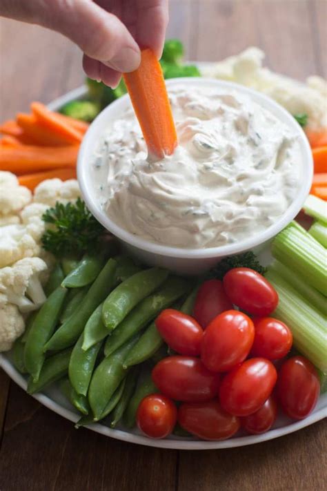 a plate with carrots, celery, broccoli and cauliflower dip