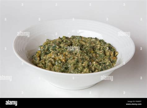 A bowl umbhidvo wetintsanga consisting of cooked pumpkin leaves, shoots and ground nuts - a ...