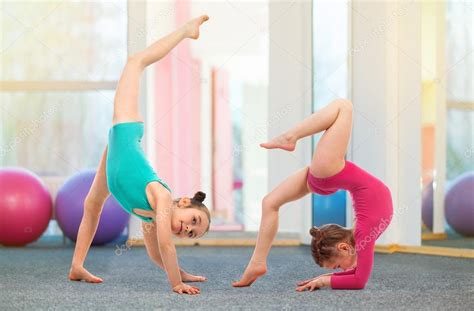 Flexible kids gymnasts doing acrobatic exercise in gym. Sport concept ...