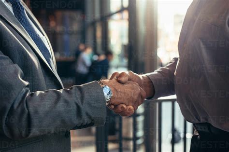 Close up of businessmen handshake at cafe. Cropped shot of two senior ...