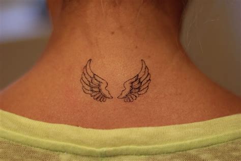 a woman with a tattoo on her neck has an angel wings design on her back