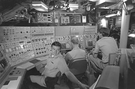 Three crewmen in the control room simulate diving operations during ...