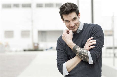 Portrait of smiling man with tattoo on his left arm stock photo