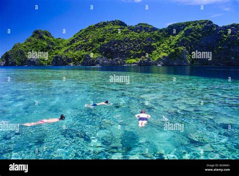 Tourists snorkeling in the crystal clear water in the Bacuit archipelago, Palawan, Philippines ...