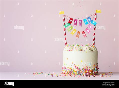 Birthday cake with brightly colored happy birthday banner Stock Photo - Alamy