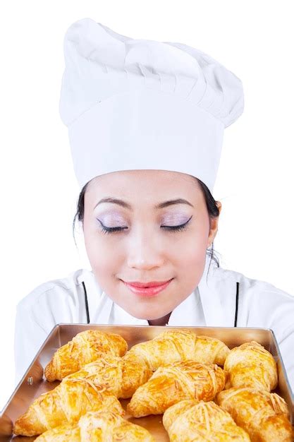 Premium Photo | Asian baker smells croissant isolated