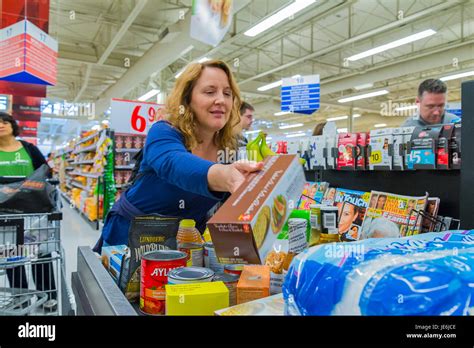 Woman placing groceries on Grocery store checkout belt Stock Photo - Alamy