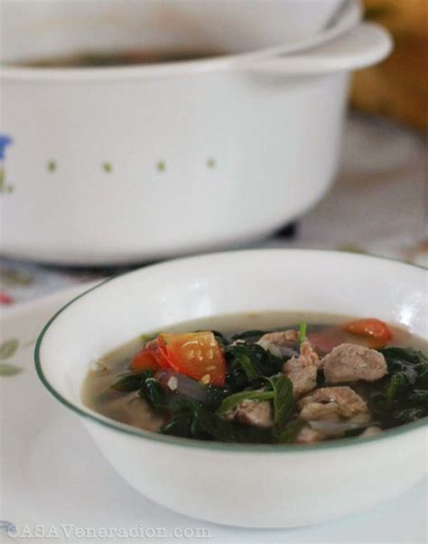 a bowl of soup with meat and vegetables on a plate next to a casserole dish