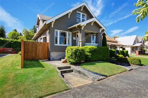 Classic American house exterior with siding trim and well kept garden ...