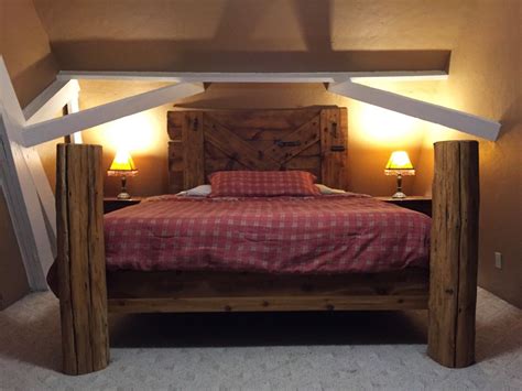 a bed with two lamps on either side of it and a wooden frame in the middle