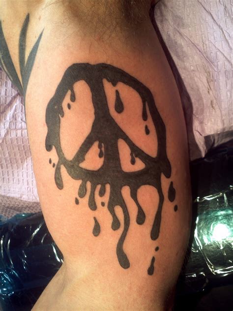 a man with a peace sign tattoo on his arm and shoulder is covered in ...