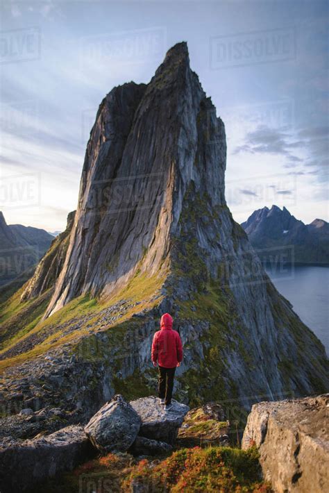 Norway, Senja, Man standing in front of Segla mountain at sunrise ...