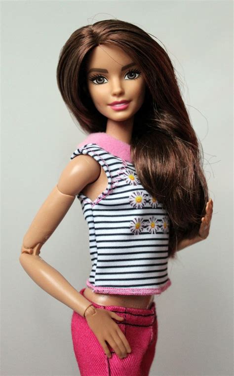 a doll with long brown hair wearing pink pants and a striped shirt ...