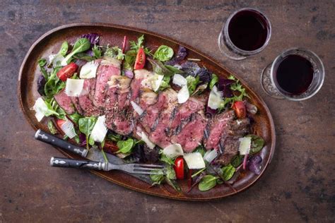 Traditional Italian Tagliata Steak with Parmesan and Salad on a Rusitc ...