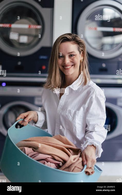 Young woman waiting in a laundry room Stock Photo - Alamy