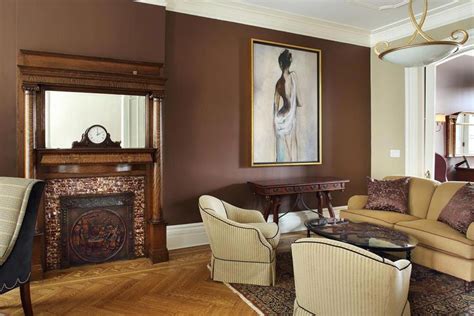 Chocolate brown walls create a warm, inviting atmosphere in this formal living room that conta ...