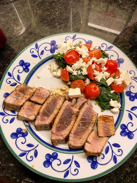 Seared tuna steak with a side of spinach, tomato and feta cheese ...