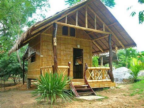 a small wooden cabin with steps leading to the front door and stairs up to the second floor