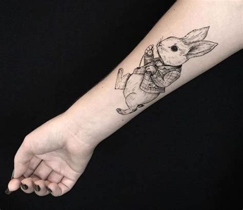 a person's arm with a small tattoo of a rabbit holding a piece of luggage