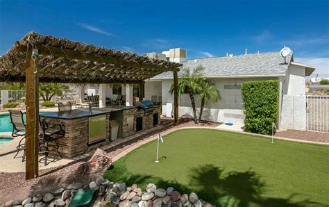 Backyard putting green with pool outdoor kitchen and wood pergola ...