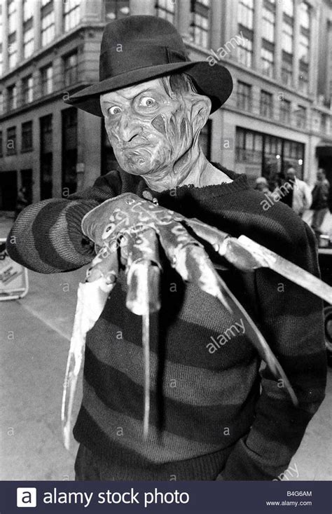 an old photo of a man dressed up as a zombie holding something in his hand