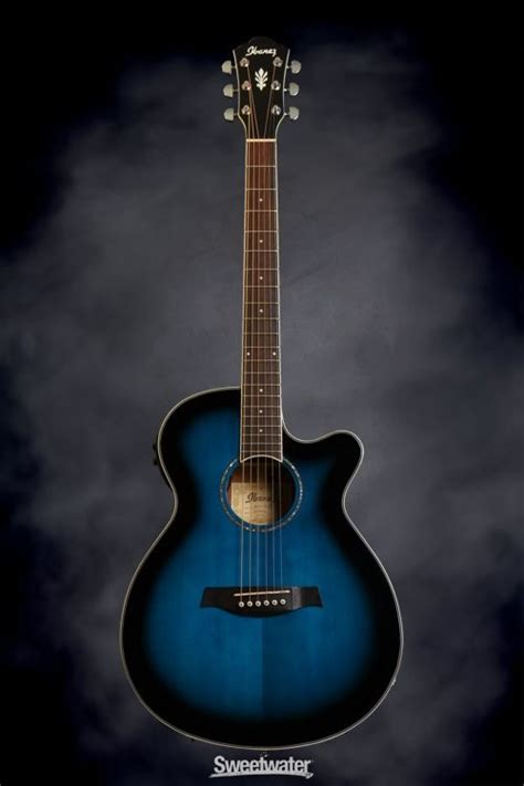 an acoustic guitar is shown against a dark background