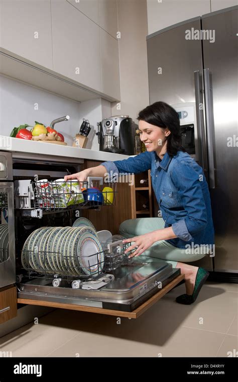 woman unloading dishwasher Stock Photo - Alamy