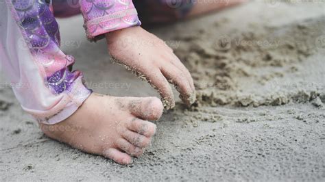 Close Up portrait of kids feet and hand playing with sand. Sensory education with nature concept ...