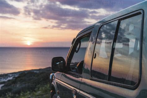 Car at beach during sunset stock photo