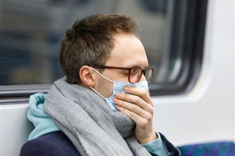 Premium Photo | Ill man coughing, wearing protective mask in public ...