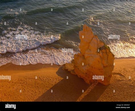 Rock At Beach During Sunset Stock Photo - Alamy