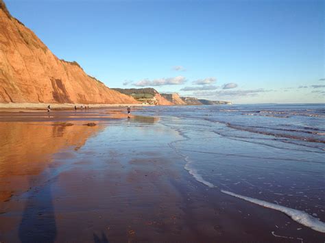 Red cliffs reflecting on the wet sand at low tide. Sidmouth | East Devon