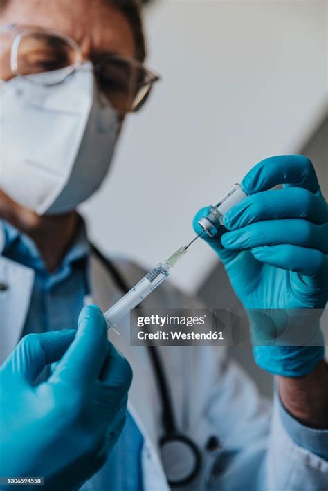 Male General Practitioner Filling Syringe With Covid19 Vaccine While ...