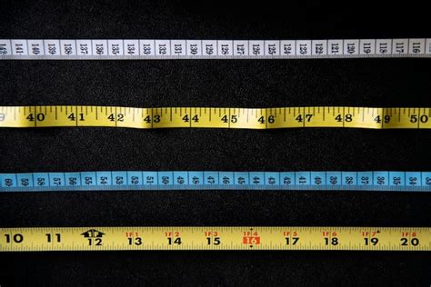 Premium Photo | Various measuring tape in white yellow and blue on black surface overhead