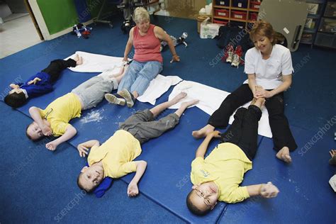 Carers at special school giving children foot massages - Stock Image - C046/7390 - Science Photo ...