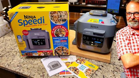 a man standing in front of an open box of ninja speed ii rice cooker