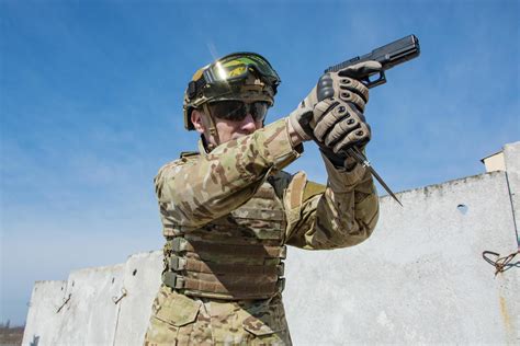 Male soldier in nato uniform with hand gun outoors in the field 7567305 ...