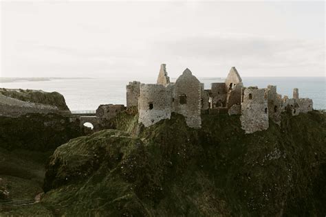 old medieval ruins of Dunluce Castle on ocean coast in northern Ireland famous place in uk ...